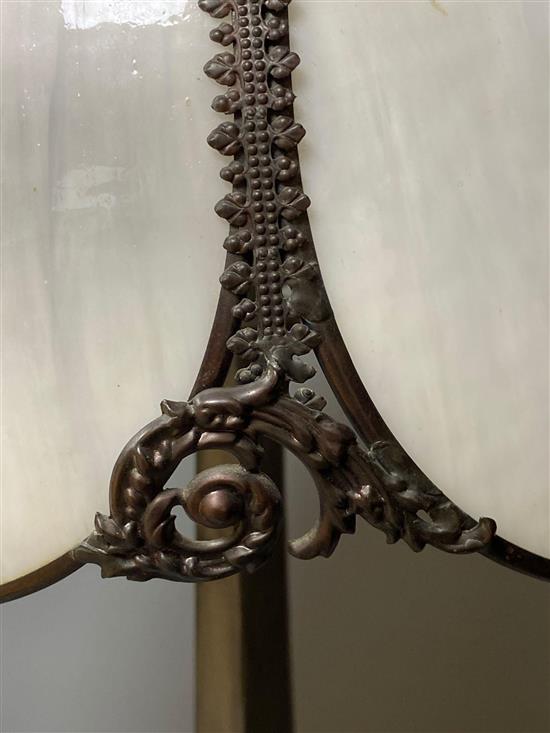 An Art Nouveau style metal table lamp with opaque white glass petal shade